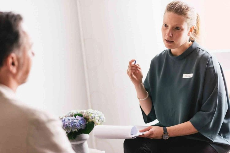 Frau spricht mit Patienten